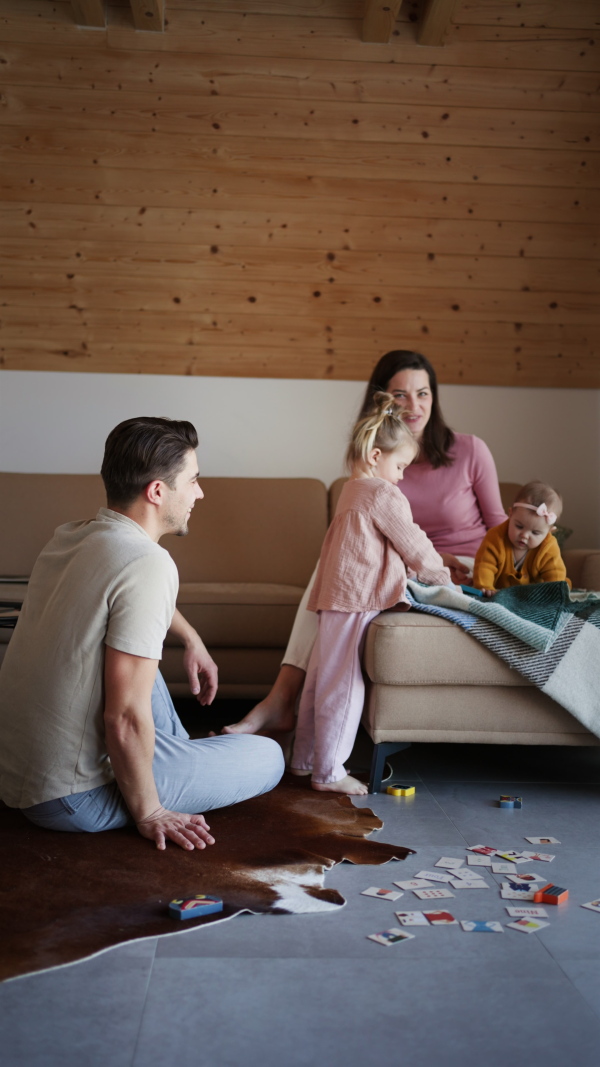 A happy young family with small children having fun in cabin on holiday.