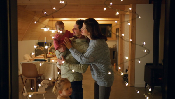 A happy young family with small children in cabin on holiday, looking at camera.