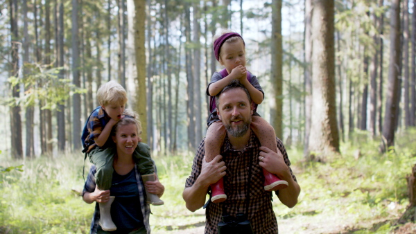 A family with small children walking outdoors in summer nature.