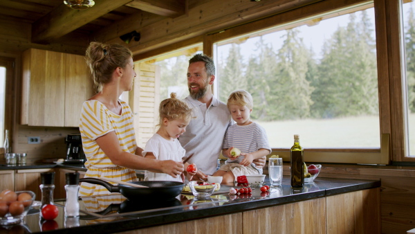 A family with small children cooking indoors, holiday in private apartment.