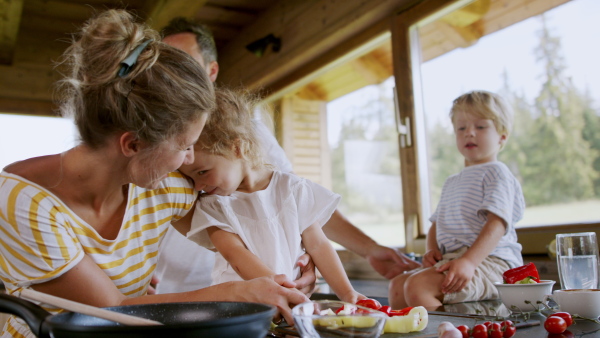 A family with small children cooking indoors, holiday in private apartment.