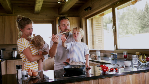 A family with small children cooking indoors, holiday in private apartment.