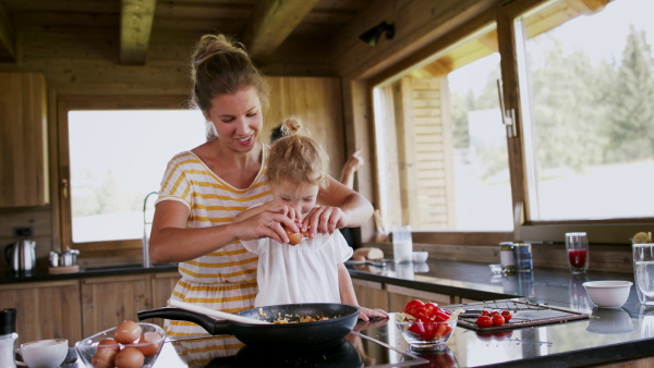 A family with small children cooking indoors, holiday in private apartment.