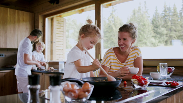 A family with small children cooking indoors, holiday in private apartment.