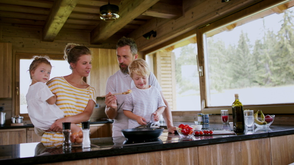 A family with small children cooking indoors, holiday in private apartment.