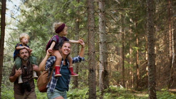 A family with small children walking outdoors in summer nature.