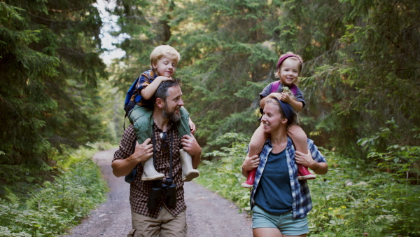 A family with small children walking outdoors in summer nature.