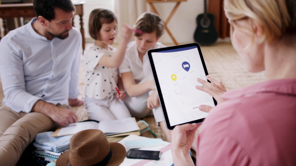 Beautiful young family making preparations for vacation on tablet.