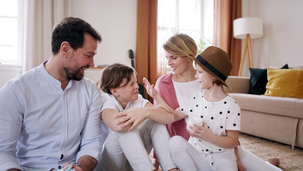 Beautiful family preparing for vacation, little daughter playing with sun lotion.