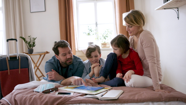 A beautiful family packing and making preparations for vacation on tablet.