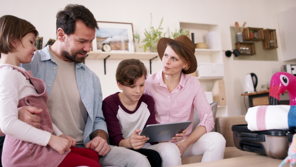 A beautiful family packing, making preparations for vacation on tablet.