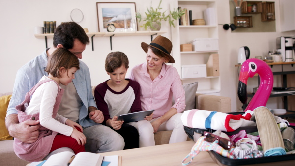 A beautiful family making preparations for vacation on tablet.