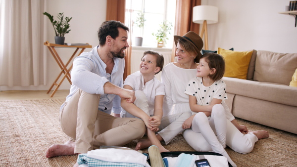 Beautiful young family packing and making preparations for vacation.