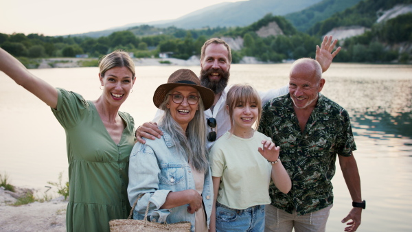 A happy multigeneration family on hiking trip on summer holiday, taking selfie.