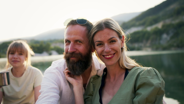 A happy mature couple in love hugging in nature, looking at camera.