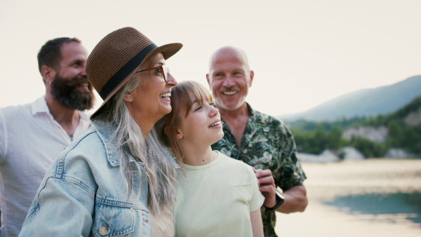 A happy multigeneration family on hiking trip on summer holiday, walking.