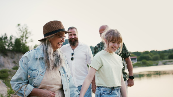 A happy multigeneration family on hiking trip on summer holiday, walking.