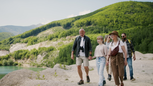 A happy multigeneration family on hiking trip on summer holiday, walking.