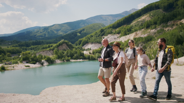 A happy multigeneration family on hiking trip on summer holiday, walking.