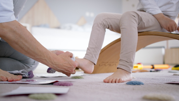 Busy mother preparing her daughter for kindergarten. Close up of foot and socks.