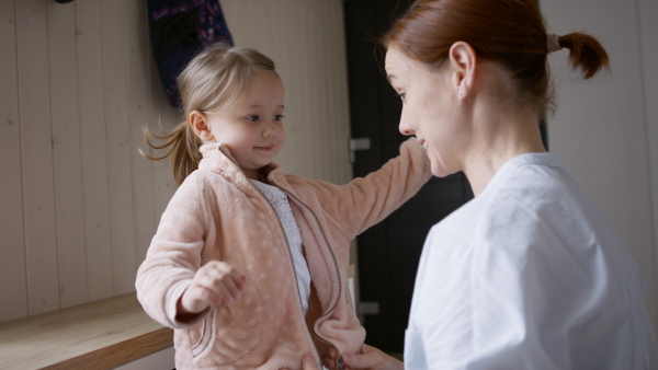 Busy mother preparing her daughter for kindergarten.