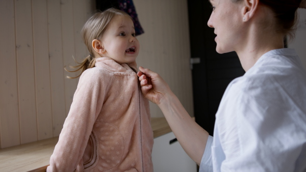 Busy mother preparing her daughter for kindergarten.