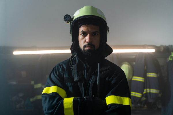 A young African-American firefighter in fire station at night.