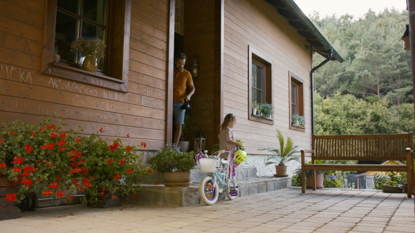 Mature father preparing his daughter for bike riding training.