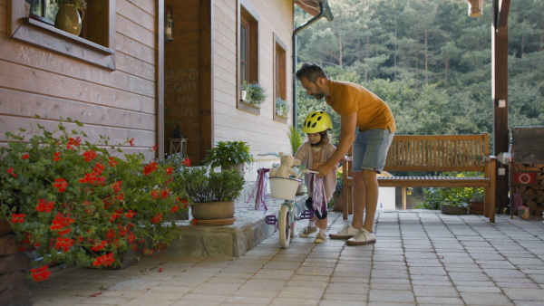 Mature father teaching his daughter how to ride a bike.