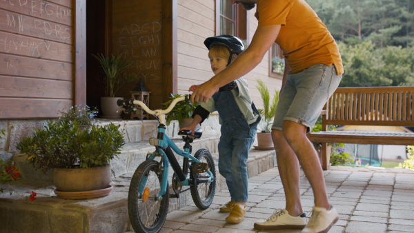 Mature father teaching his son how to ride a bike.