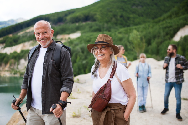 A happy multigeneration family on hiking trip on summer holiday, walking.