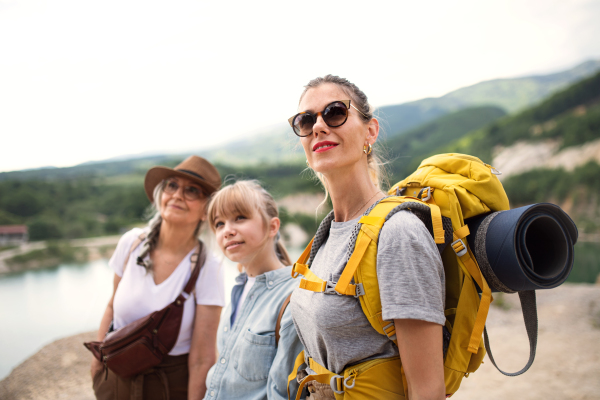 A happy multigeneration family on hiking trip on summer holiday, walking.