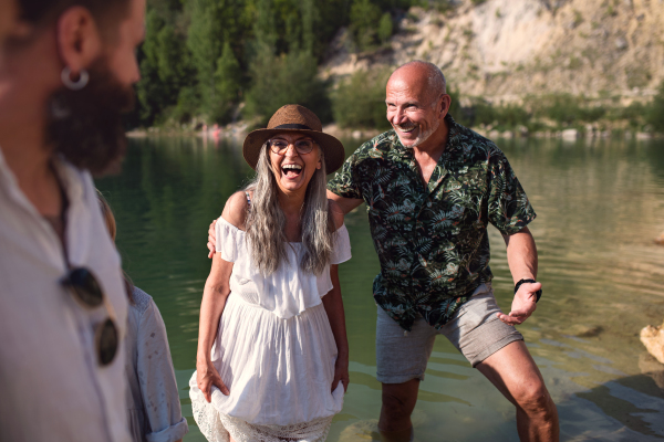 Portrait of happy multigeneration family on summer holiday, having fun by lake.