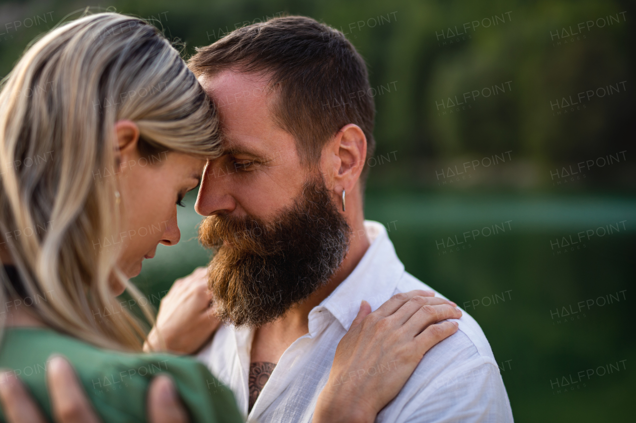 Portrait of happy mature couple in love hugging in nature.