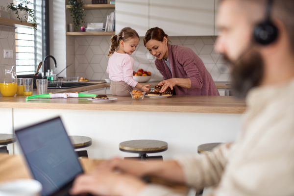 Mature businessman having video call indoors at home, everyday life and home office with child concept.