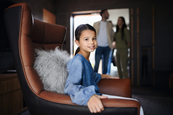 A happy little girl with parents enjoying time at luxury hotel, summer holiday.