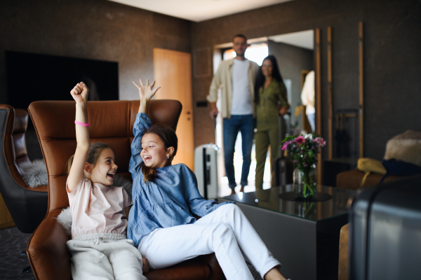 A happy two sisters with parents enjoying time at luxury hotel, summer holiday.