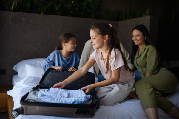 A happy young family with two children enetring room at luxury hotel, summer holiday.