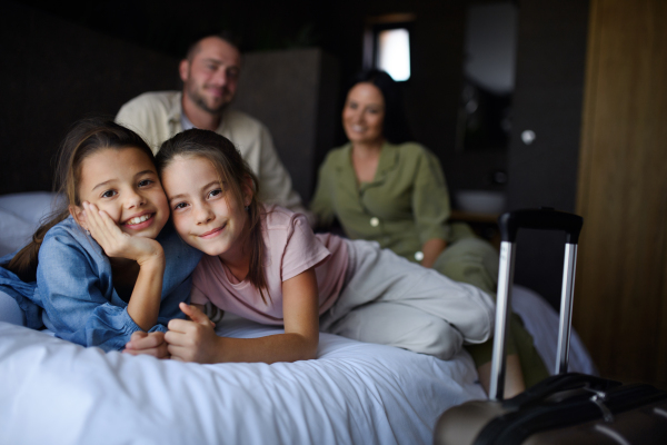 A happy young family with two children enetring room at luxury hotel, summer holiday.