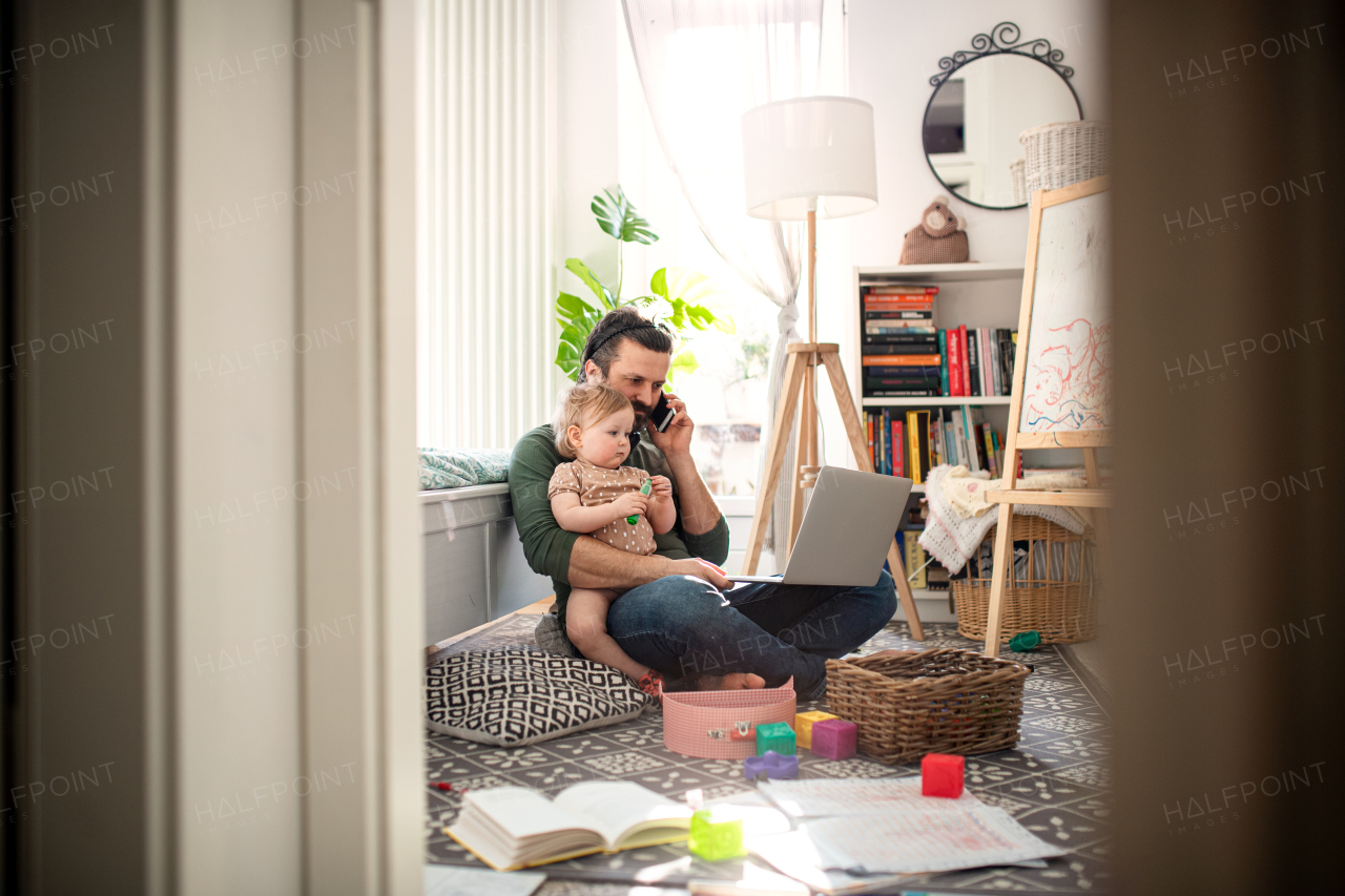 Busy father working with small toddler daughter in bedroom home office concept.