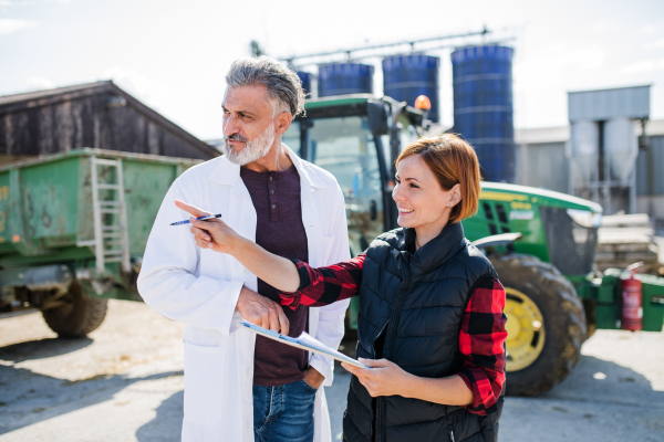 Front view of man and woman managers working on diary farm, agriculture industry.