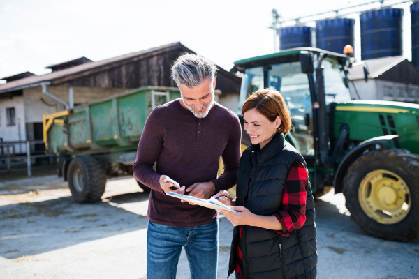 Man and woman workers working on a diary farm, agriculture industry.