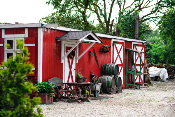 Countryside red and white farm building on summer day.