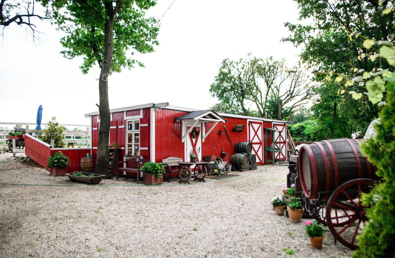 Countryside red and white farm building on summer day.