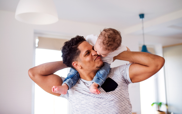 Cheeful father and small toddler son indoors at home, playing.