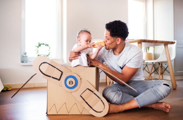 Cheeful father and small toddler son indoors at home, playing.