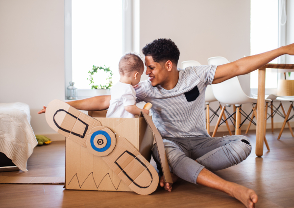 Cheeful father and small toddler son indoors at home, playing.