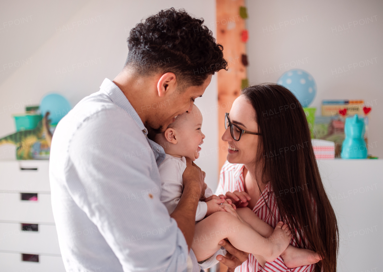 A portrait of young family with small toddler son indoors at home, having fun.