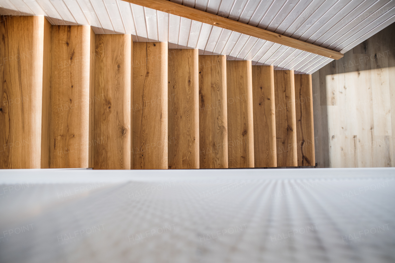 A top of wooden staircase and white wood board wall in an interior of a house. Copy space.