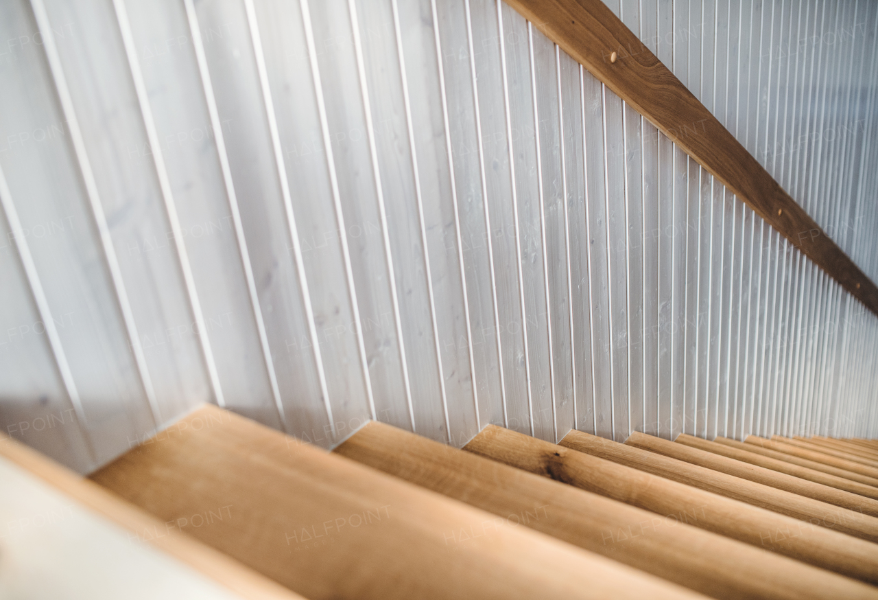 Wooden staircase and white wood board wall in an interior if a house. Copy space.